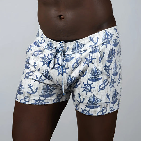 White linen nautical linen texture shorts featuring a blue anchor sailboat and ship wheel pattern on swim trunks