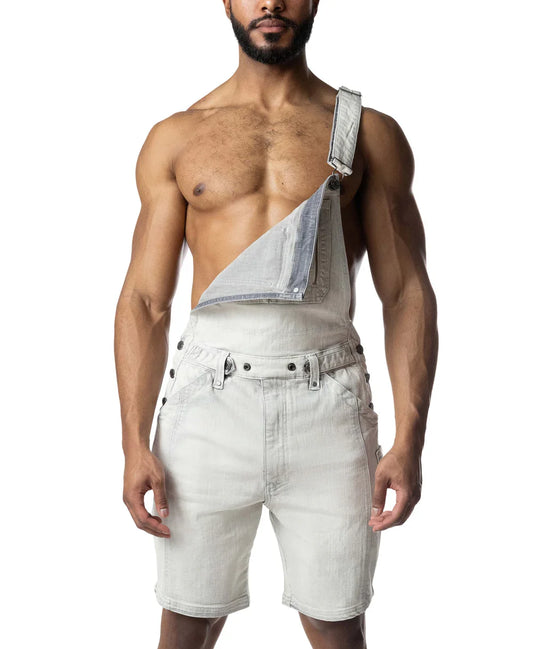 Bleached denim overall shorts with one strap unhooked, shown on a shirtless person.