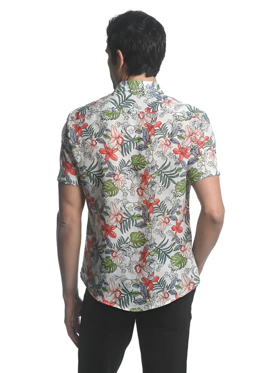 A man wearing an orchids tencel linen short-sleeved woven shirt with a vibrant red green and gray floral pattern on off-white