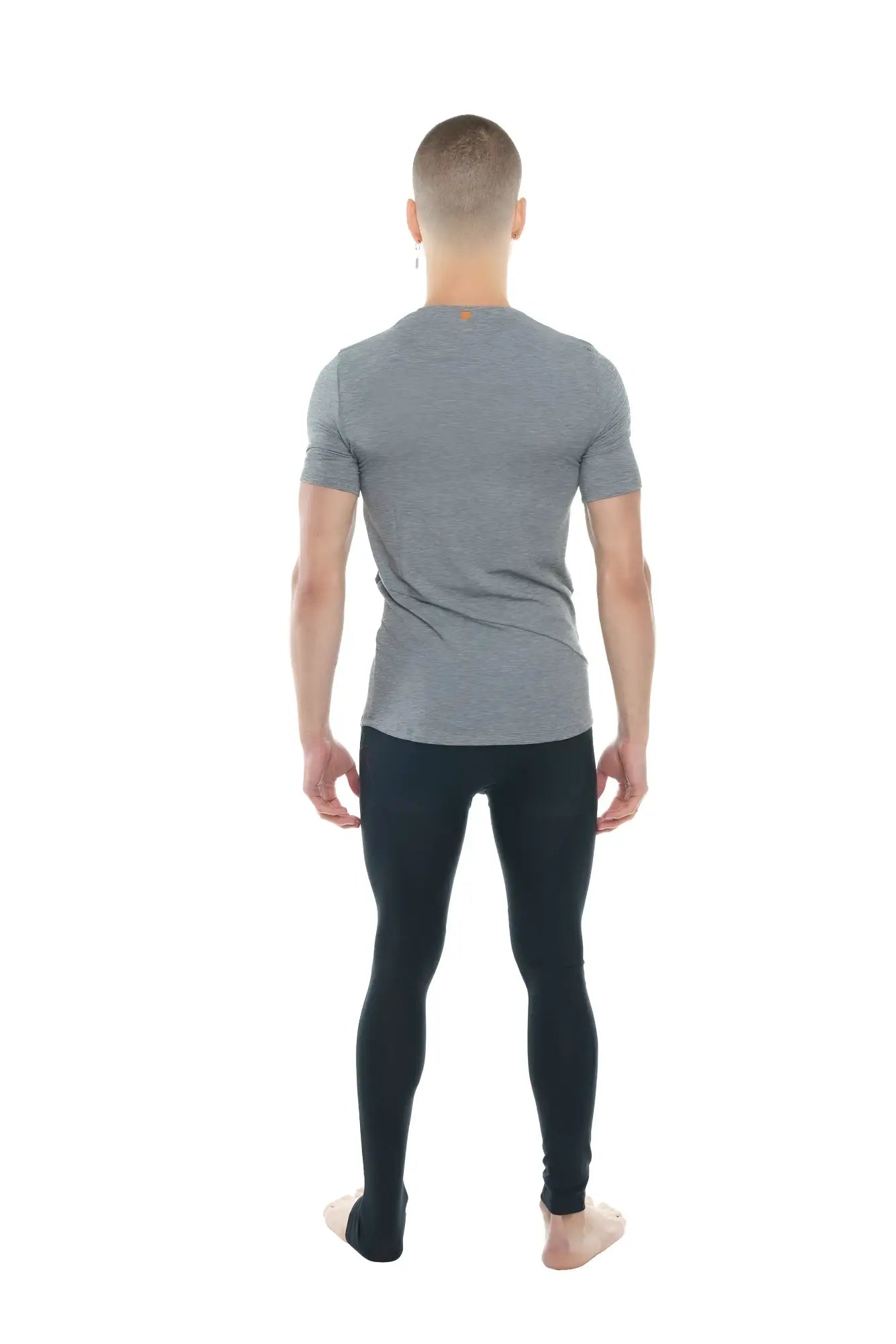 A man wearing a heather gray perfect pocket crew-neck tee in steel heather with black leggings