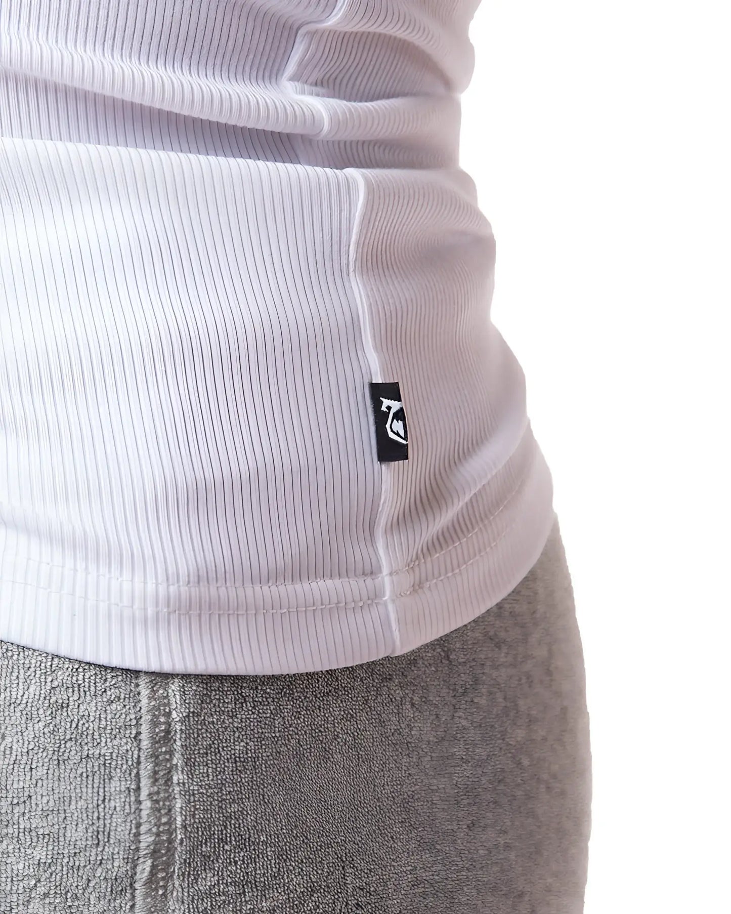 White ribbed knit pig rib tank top with small black logo tag at the hem