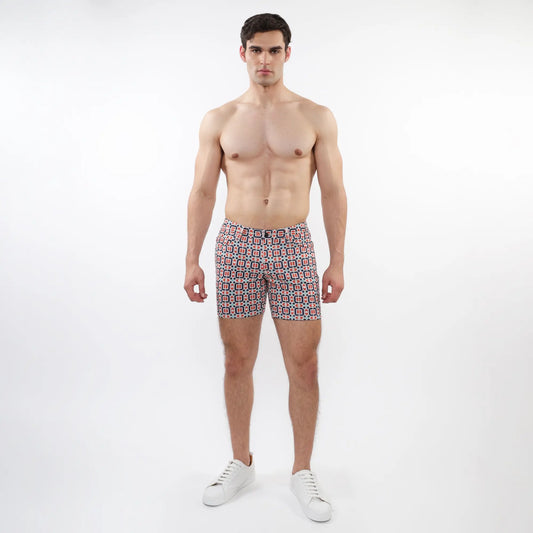 Printed stretch knit short men’s swim trunks with red blue and white geometric patterned design