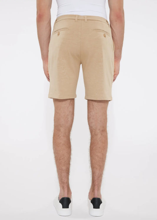 Beige solid stretch knit chino shorts with tailored fit and buttoned back pockets shown from the back side