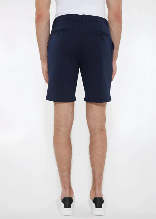 Navy blue solid stretch knit shorts with tailored sleek cut and buttoned back pockets shown from the back side