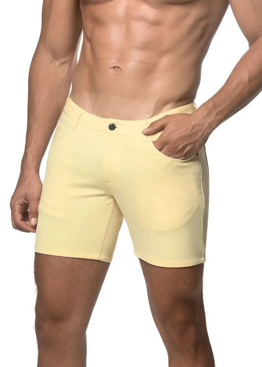 A pair of pale yellow stretch knit shorts with a classic button closure and side pockets in a form-fitting design