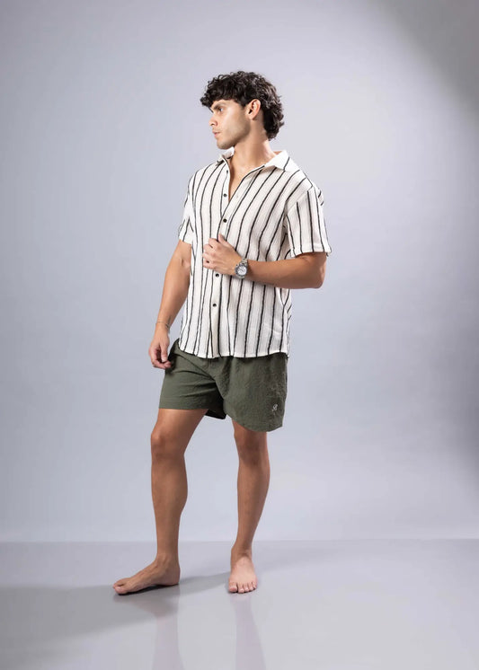 A man wearing a texture knit short-sleeved shirt with vertical black and white stripes in a casual style
