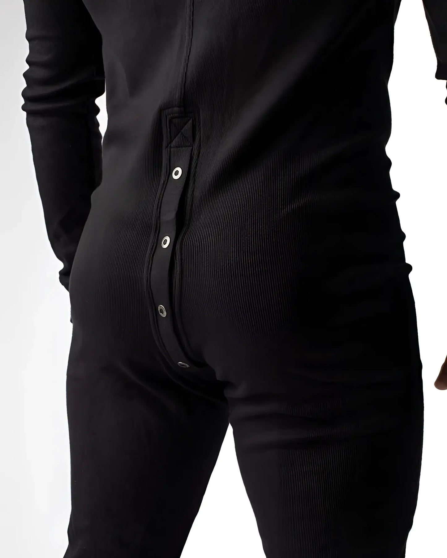 Black ribbed knit union suit pajama shown from the back with a vertical row of silver snap buttons down the spine