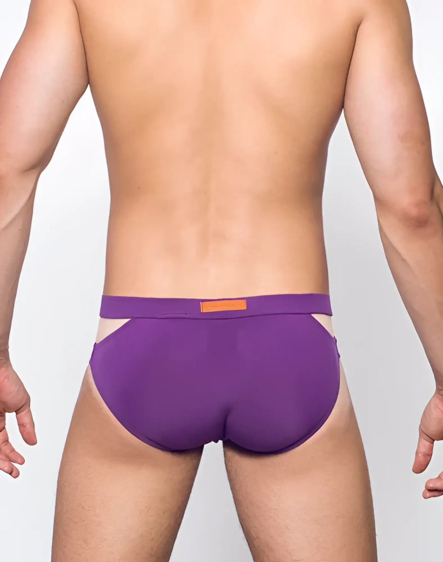 Purple VB21 BLK LABEL swim brief with contrasting orange rectangular tag on waistband designed for athletic use