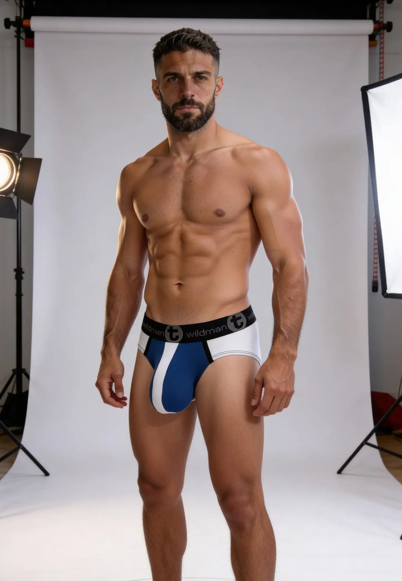 A man wearing a blue and white striped Wildman Big Boy pouch brief with a branded black waistband.