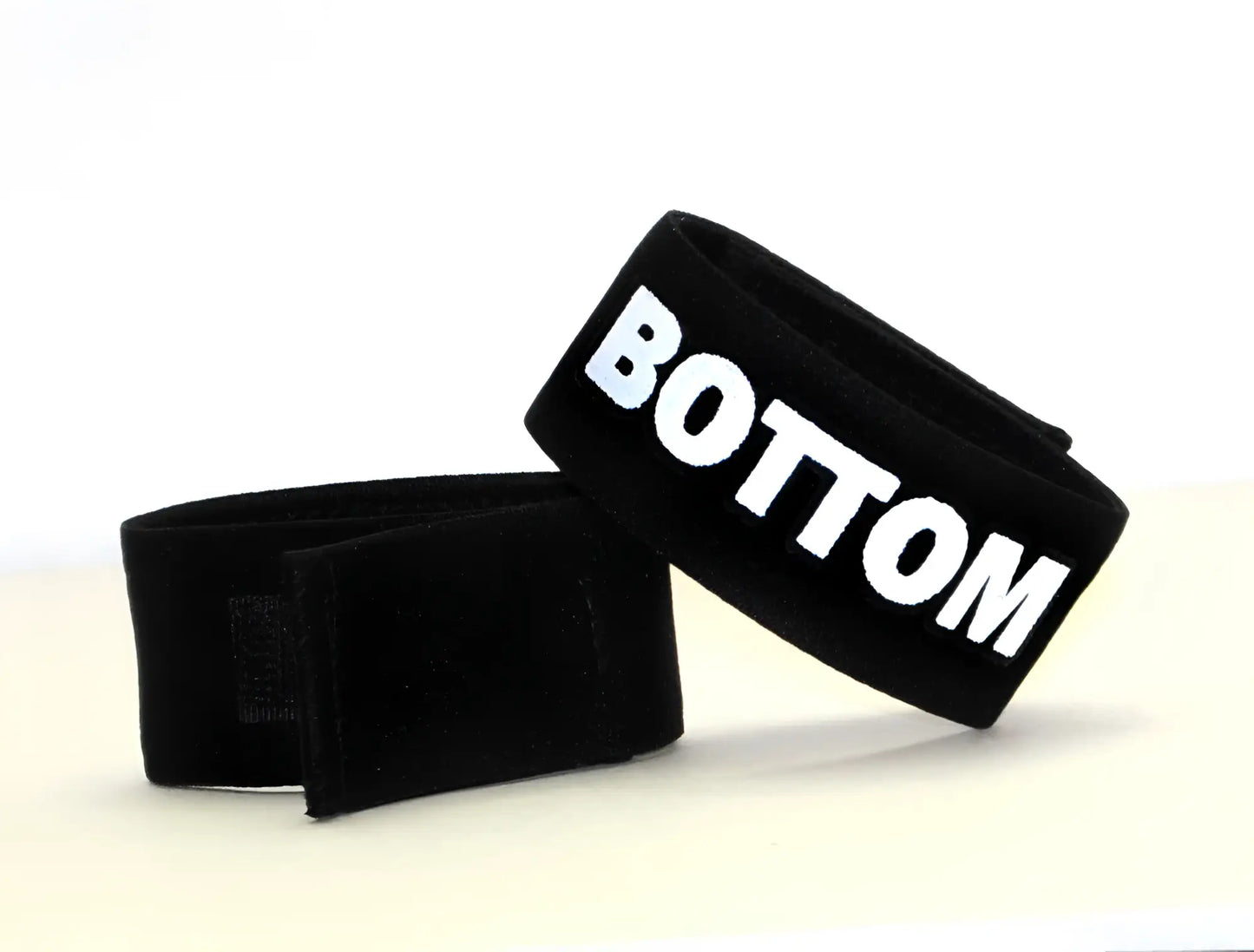 Black velour wristband with bold white bottom lettering from wildmant fetish max cock-ring bottom collection
