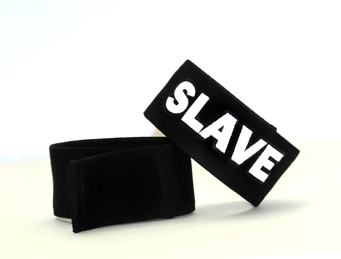Black velour wristband with bold white embroidered slave lettering from wildmant fetish max cock ring slave product
