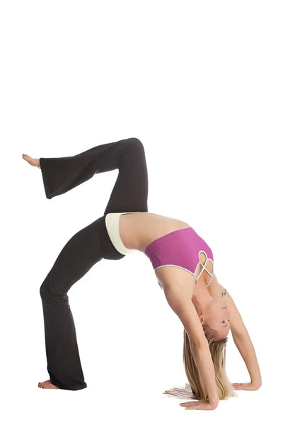 A model wears a vibrant purple sports bra and matching classic yoga pants while performing a yoga pose.