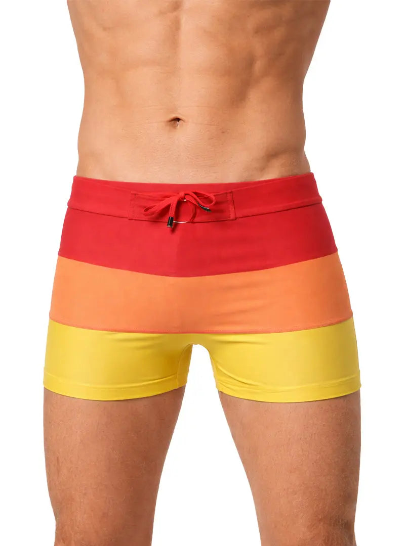Torso of a muscular man wearing tricolor red, orange, yellow swim trunks.