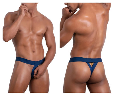 Muscular man wears blue thong with gold charm on white studio background.