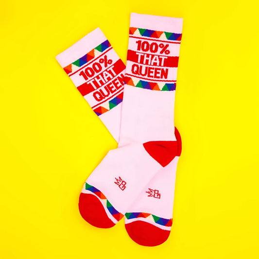 White crew socks with red accents and colorful triangles featuring bold red 100 percent that queen text on white background