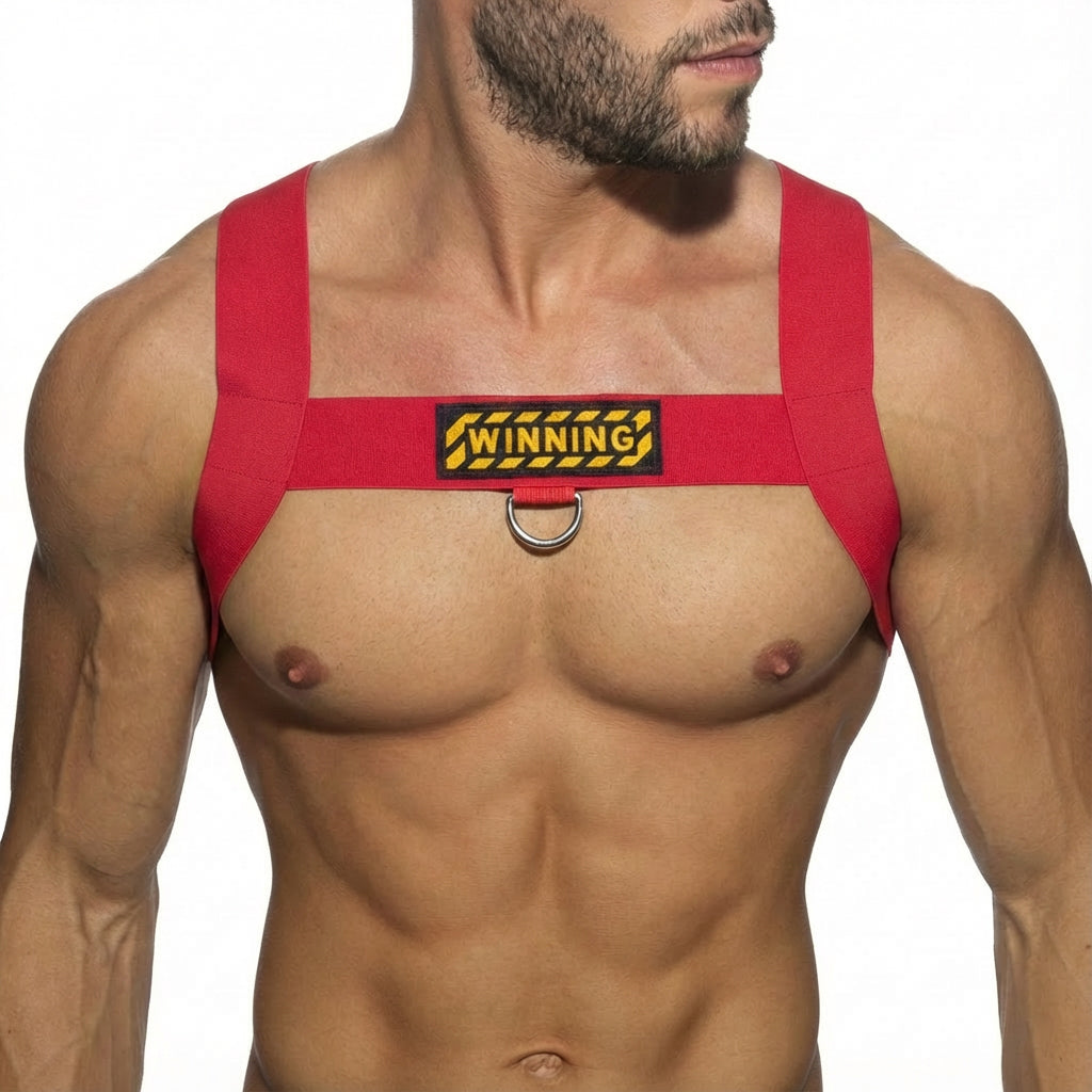 Red fabric MetroMaleWear WINNING harness with yellow and black patch and metal ring for secure fit and style