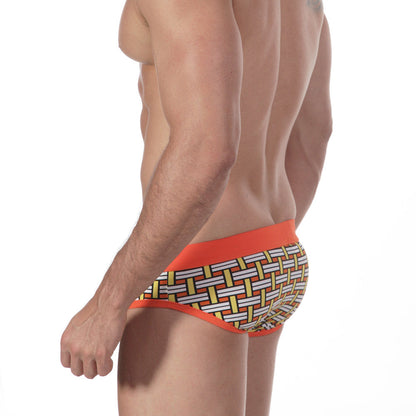 Orange-trimmed metro malewear swim brief with white yellow and black geometric basketweave pattern