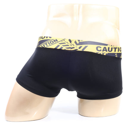 Black briefs with a bold yellow and black caution tape patterned waistband by MetroMaleWear model 2026-74