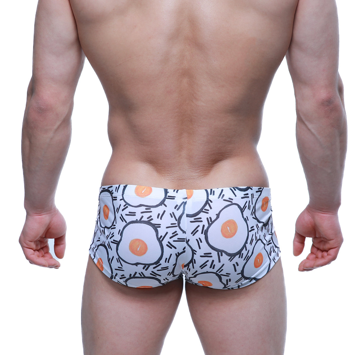 White swim trunks by metromalewear featuring a playful fried egg pattern with orange yolks and black outlines