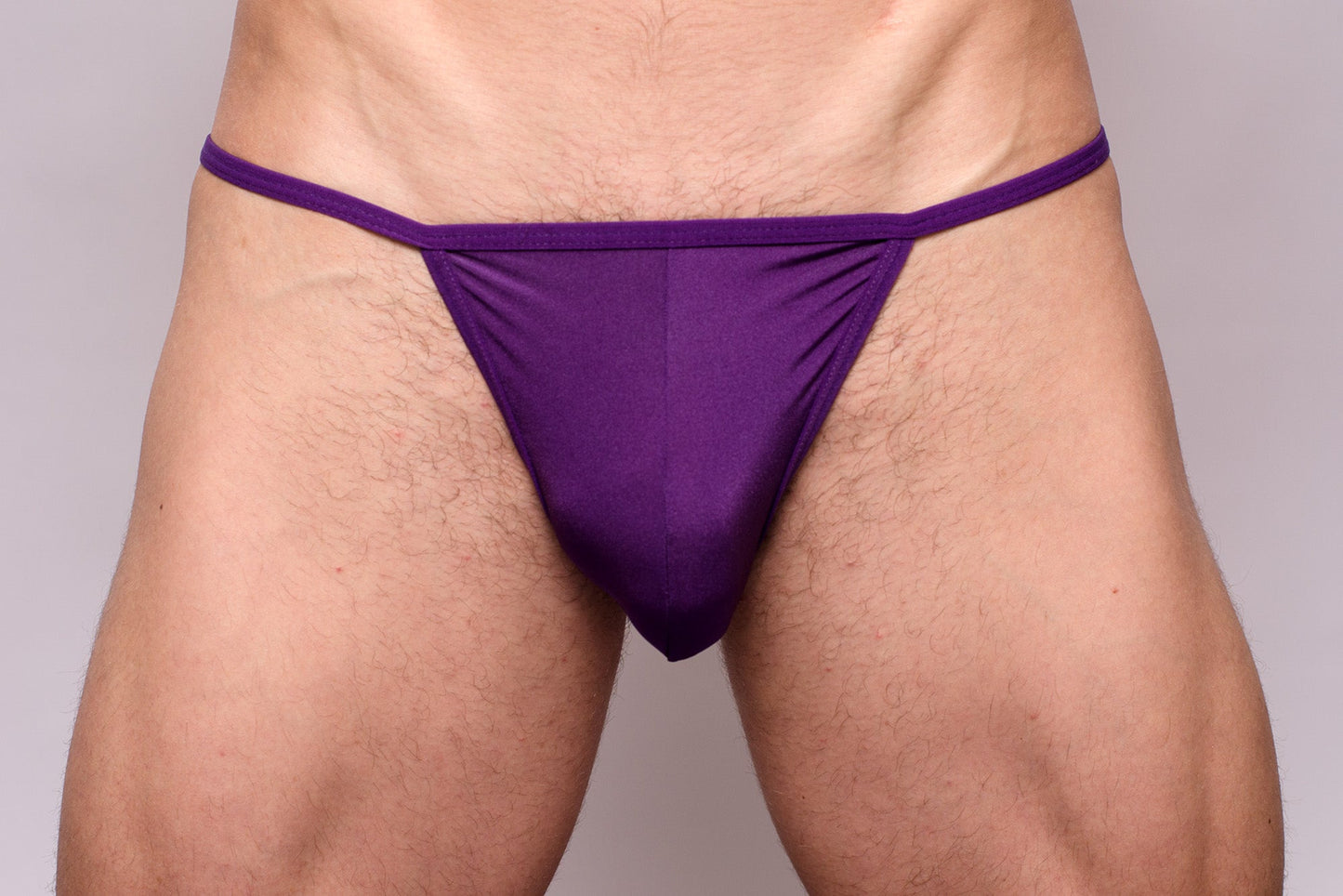 Purple thong made of smooth stretchy fabric with narrow waistband shown from the back in 3-pack pride metro string bikini