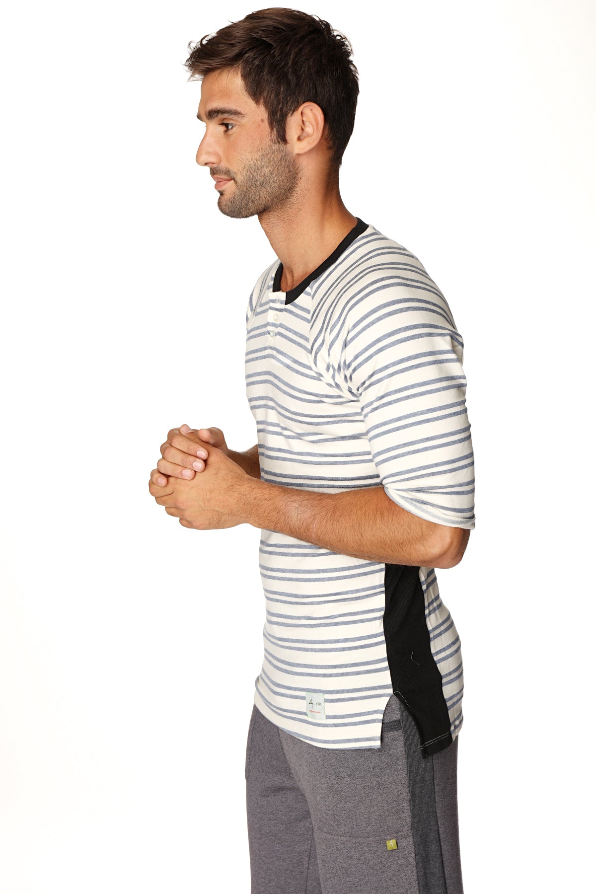 A man wearing a 4-rth mens vintage-stripe henley tee in cool blue stripe french terry loop with black trim