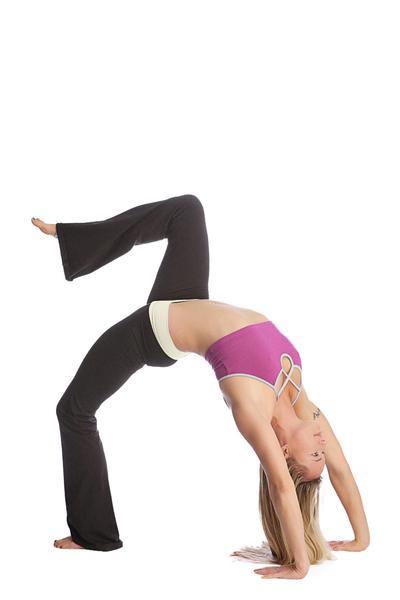 A woman in a vibrant purple sports bra and black flared 4-rth women’s classic yoga pants performs an advanced yoga pose