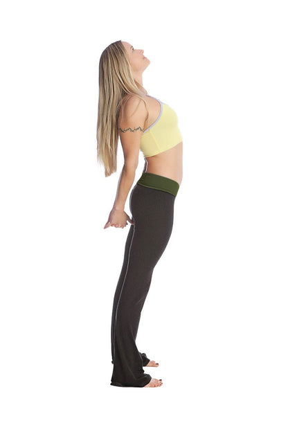 A woman wearing 4-rth women’s classic yoga pant in black with olive green waistband and a light yellow sports bra with gray trim
