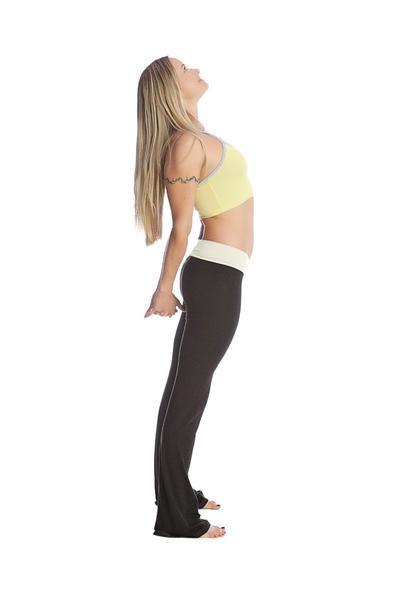 A woman wearing 4-rth women’s classic yoga pant in black with a thin side stripe and a light yellow sports bra with white trim