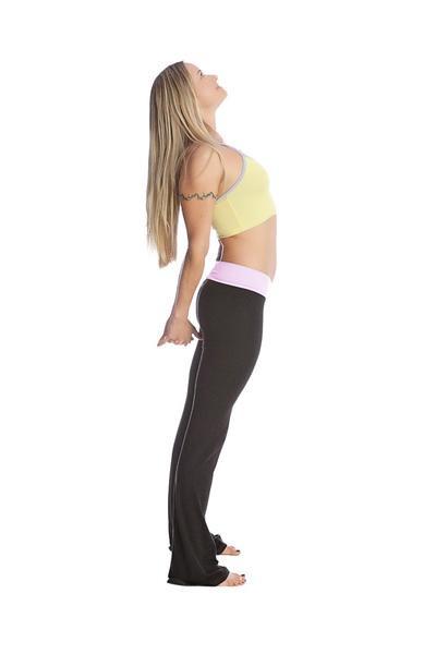 A woman wearing 4-rth women’s classic yoga pants with a light pink waistband and a yellow sports bra with thin straps