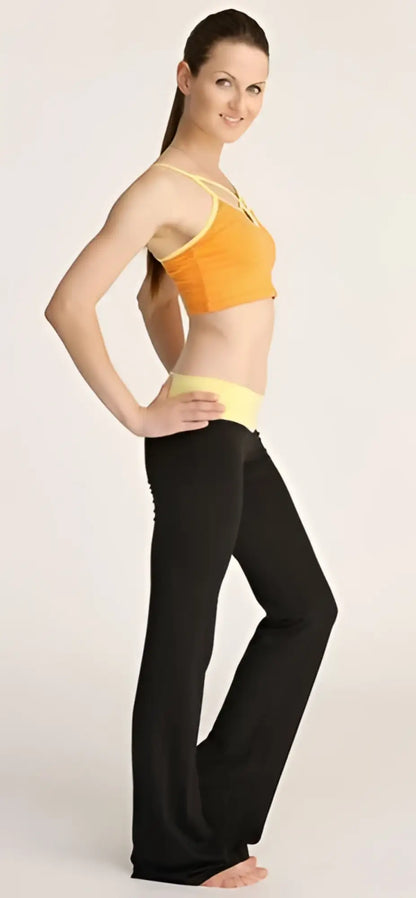 A woman wearing 4-rth women’s classic yoga pant in black flared leggings and a vibrant orange sports bra with yellow trim