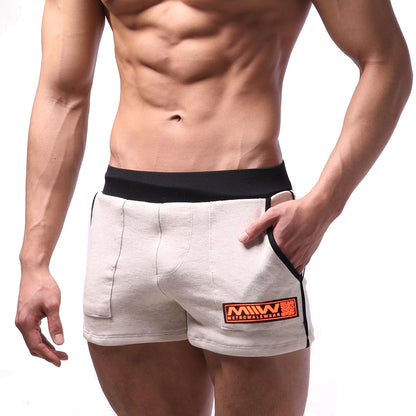 Beige cotton athletic shorts with black elastic waistband and orange logo patch by metromalewear for sports use