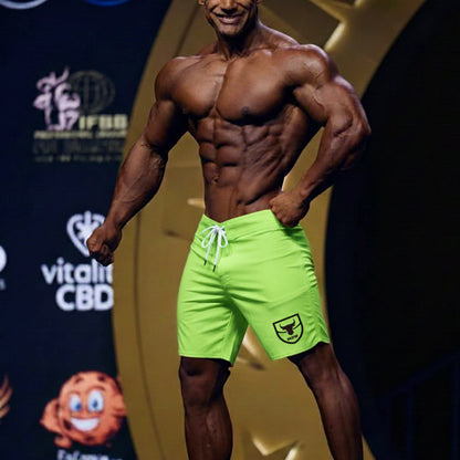 MetroMaleWear physique board short neon green with white drawstring and black shield logo on lower right leg