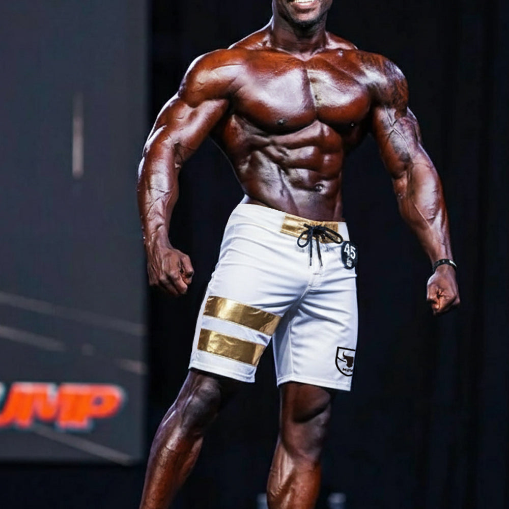 White MetroMaleWear Physique board shorts with gold stripes black logo on left leg and drawstring waistband