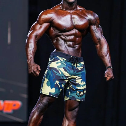 Men’s metroMalewear physique board shorts in yellow camo with black drawstring waistband and logo patch on lower left leg