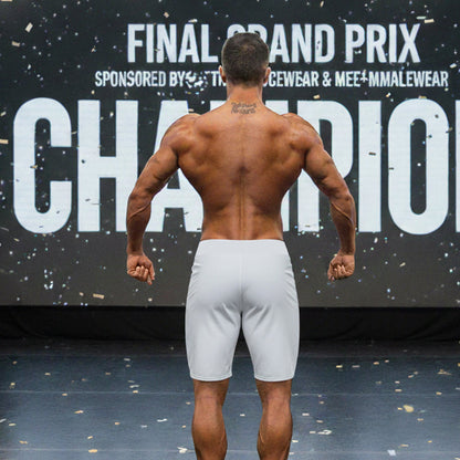 A muscular man shown from the back wearing gray metro musclwear insignia physique board shorts by metromalewear