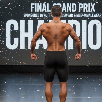 A muscular man seen from the back wearing black MetroMaleWear MetroMuscleWear Cafe Physique board shorts