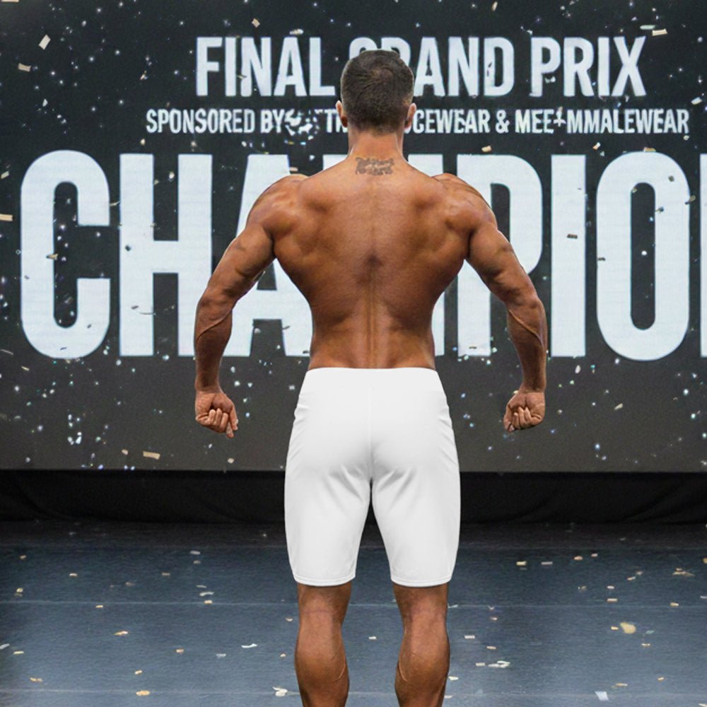 A muscular man wearing white metroMalewear metroMusclewear gold physique board shorts shown from the back