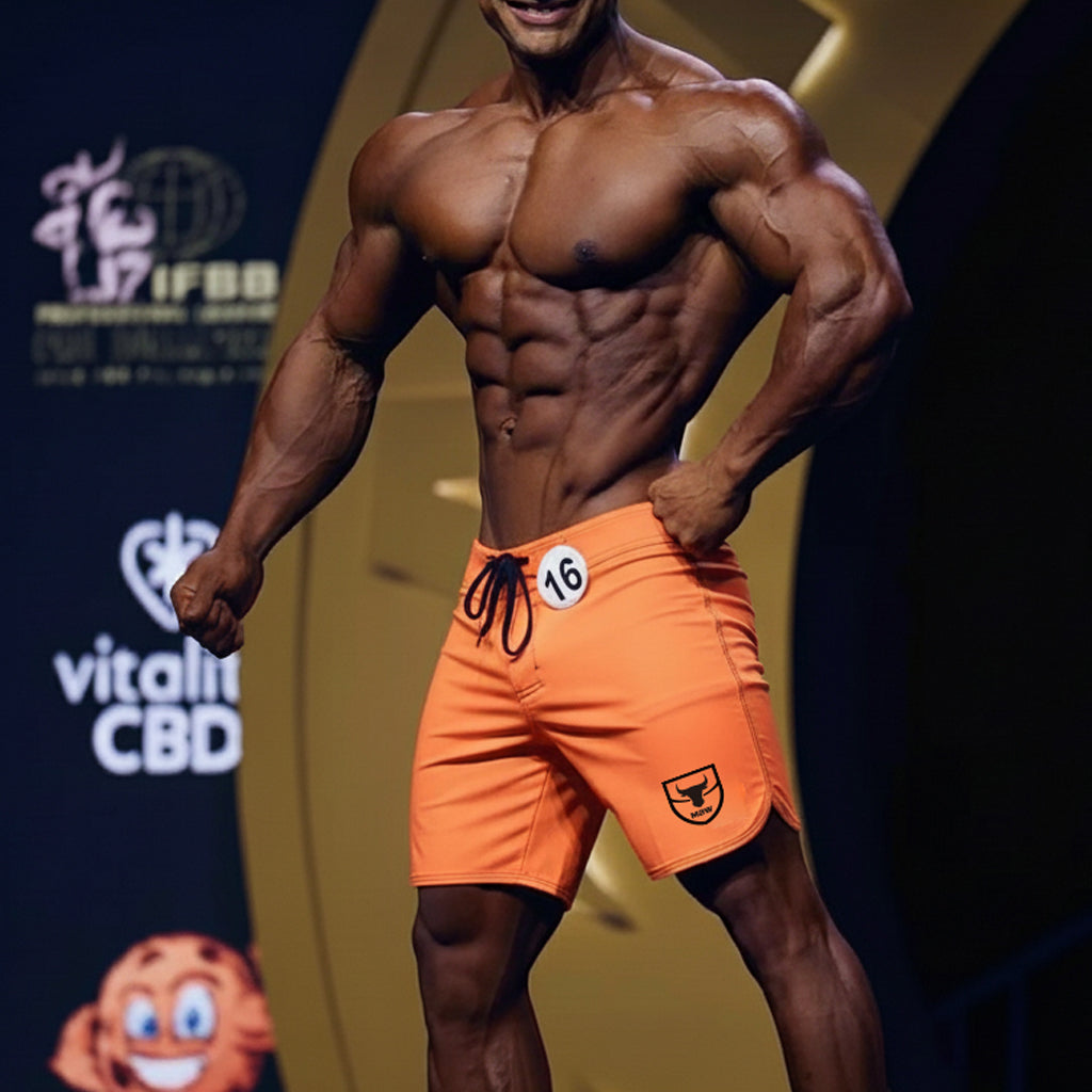 Orange metromusclewear physique board shorts with black drawstring and shield logo on lower right leg