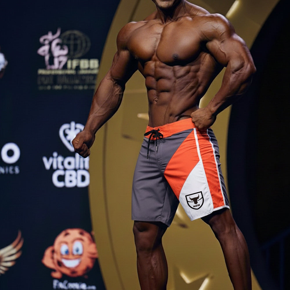 MetroMaleWear MetroMuscleWear IFBB Pro men’s physique board shorts gray orange white with black drawstring and shield logo