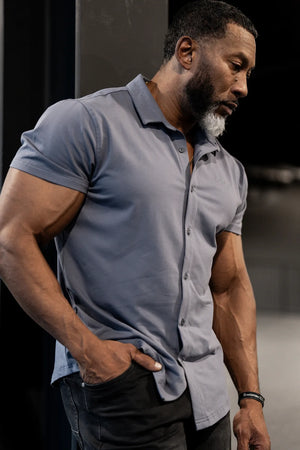 Muscle-fit short sleeve shirt in storm gray worn by a muscular man featuring a button-up design and a sleek fit by Jed North