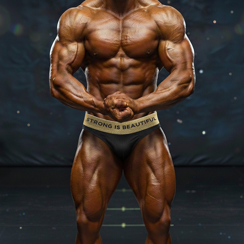 Black briefs with gold waistband featuring strong is beautiful text from metromalewear métromusclewear sib competition suit 4974-84
