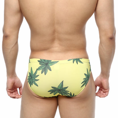 Yellow swim trunks by metromalewear featuring bold green cannabis leaf pattern for casual beachwear use