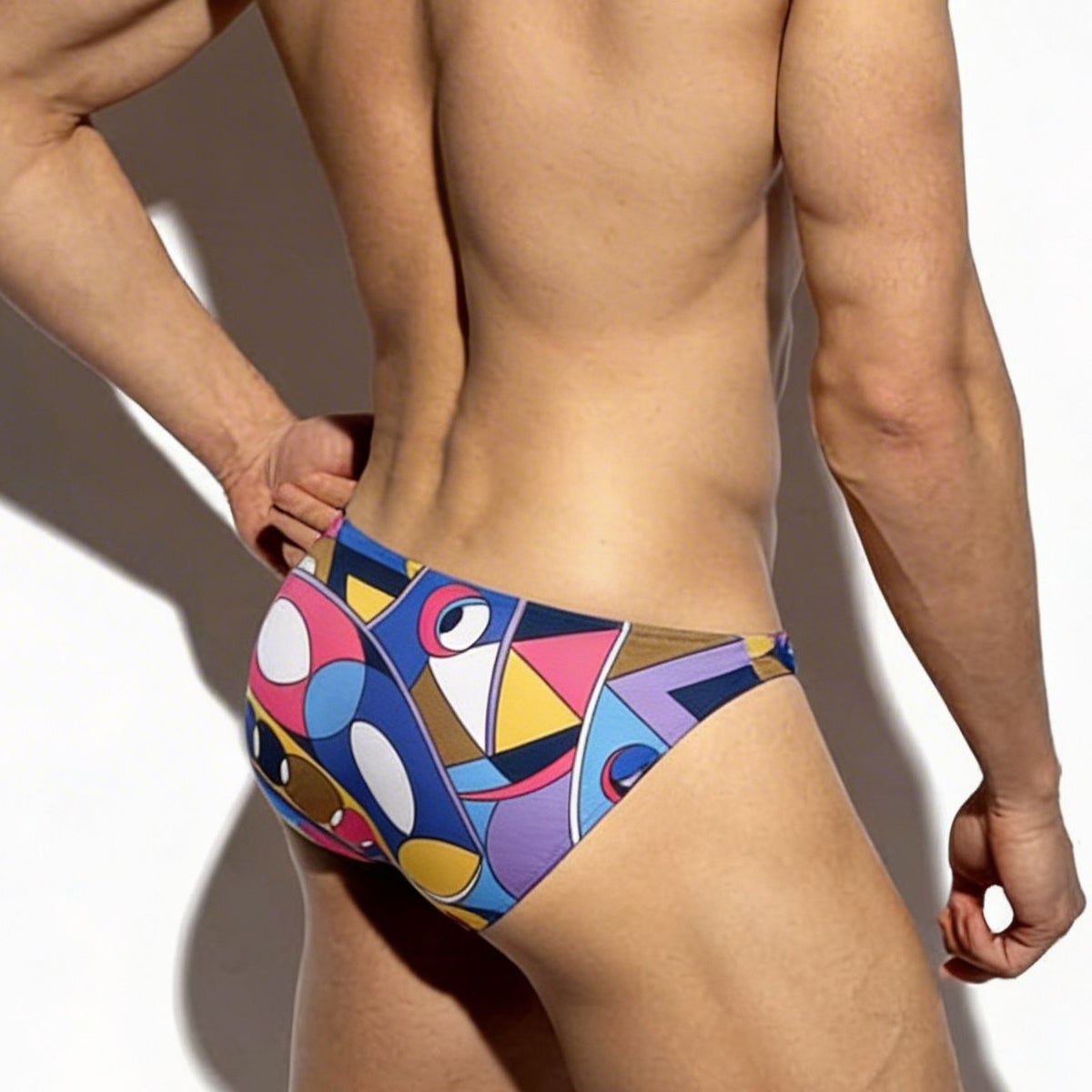 MetroMaleWear super lowrise bikini swim trunks with vibrant geometric pattern in bold blues pinks yellows and purples