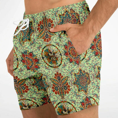 Men's swim shorts by Maris Equi in a vibrant mosaic pattern with green background featuring side pockets and a drawstring waist.