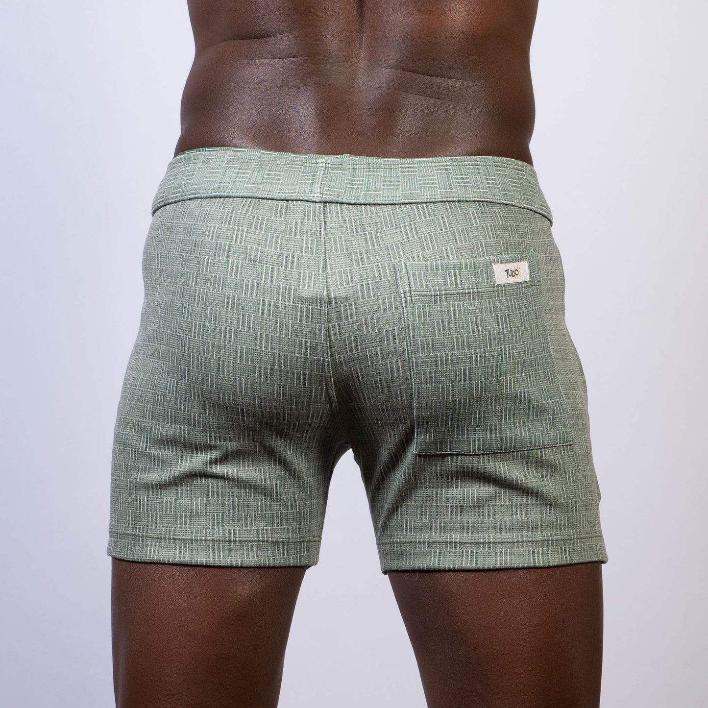 Mint green abstract linen texture shorts with subtle woven pattern and branded label on the back waistband