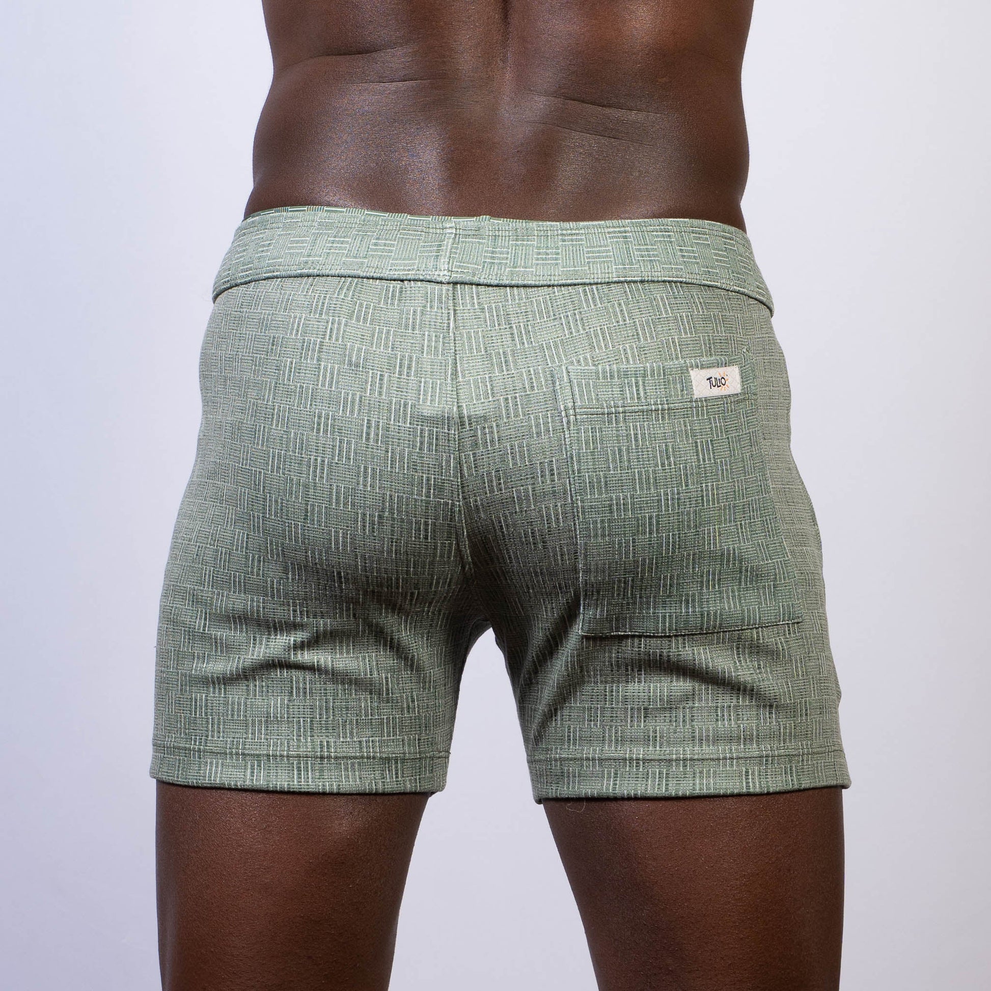 Mint green abstract linen texture shorts with subtle woven pattern and branded label on the back waistband