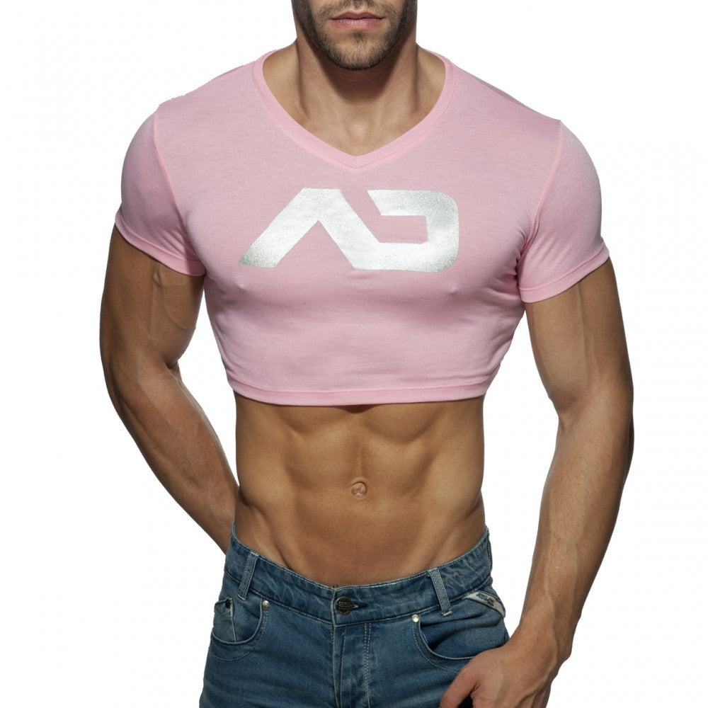 Pink cropped v-neck t-shirt with white metallic logo featuring ad crop top design in soft fabric