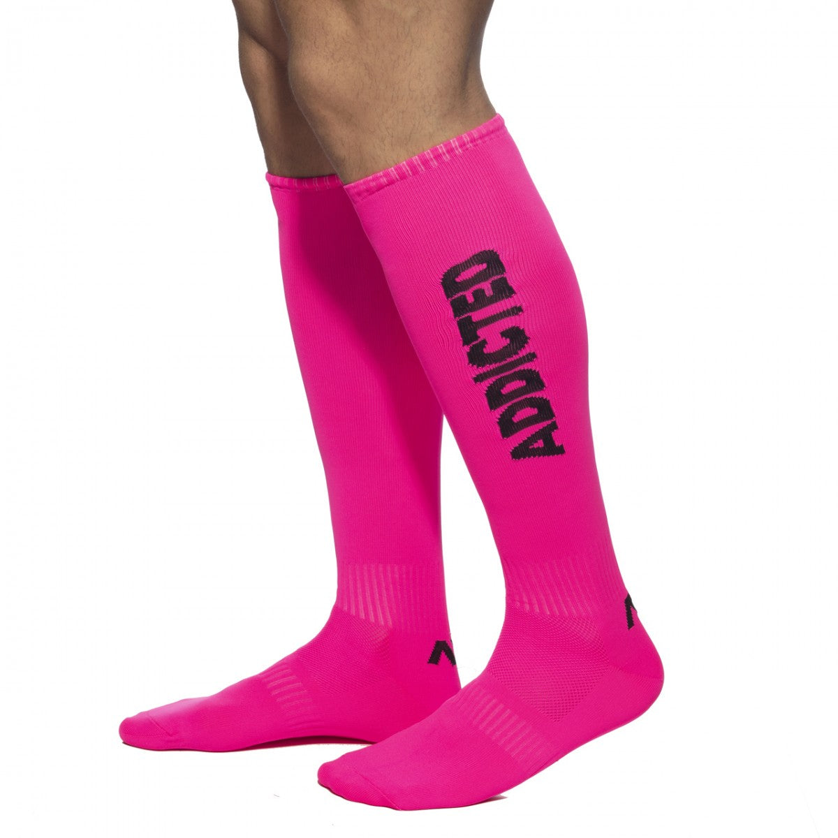 Bright pink neon knee-high socks with bold black addicted lettering down the side for stylish streetwear