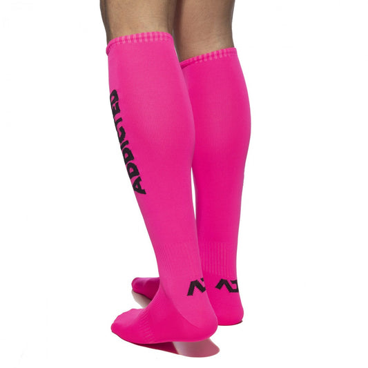 Bright pink neon knee-high socks featuring black addicted branding and logo design on the side by Addicted