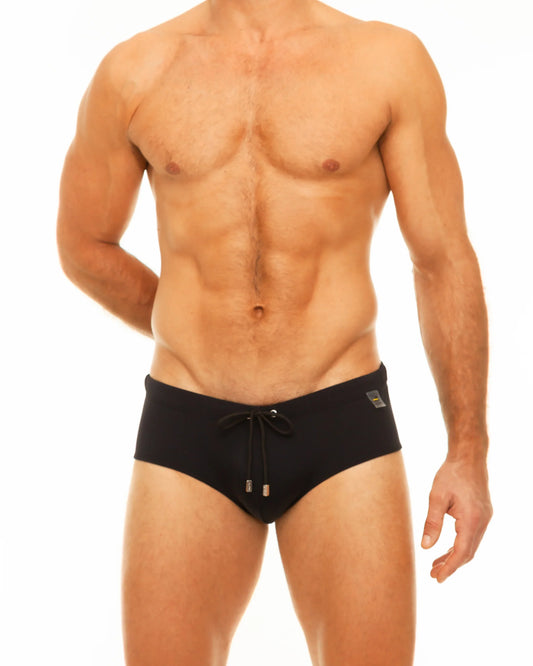 Black along solid swim brief with drawstring waistband and small metallic accents for swimming and beachwear